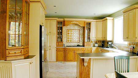 Kitchen interior featuring light wood cabinetry, stainless steel refrigerator, and a central island with seating.