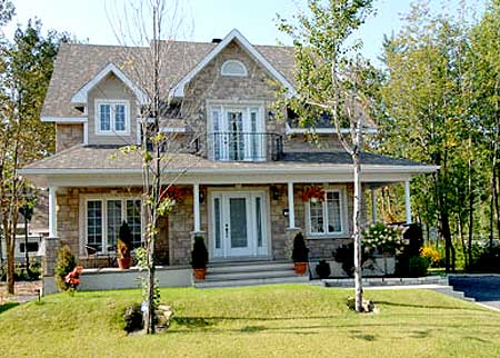 House plan exterior: Two-story stone facade with a covered front porch, gabled dormers, and a second-story balcony.