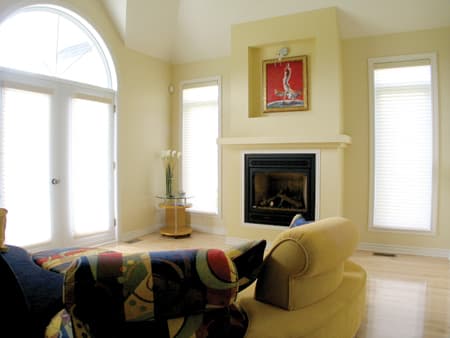 Living room interior with fireplace, arched double doors, and windows.