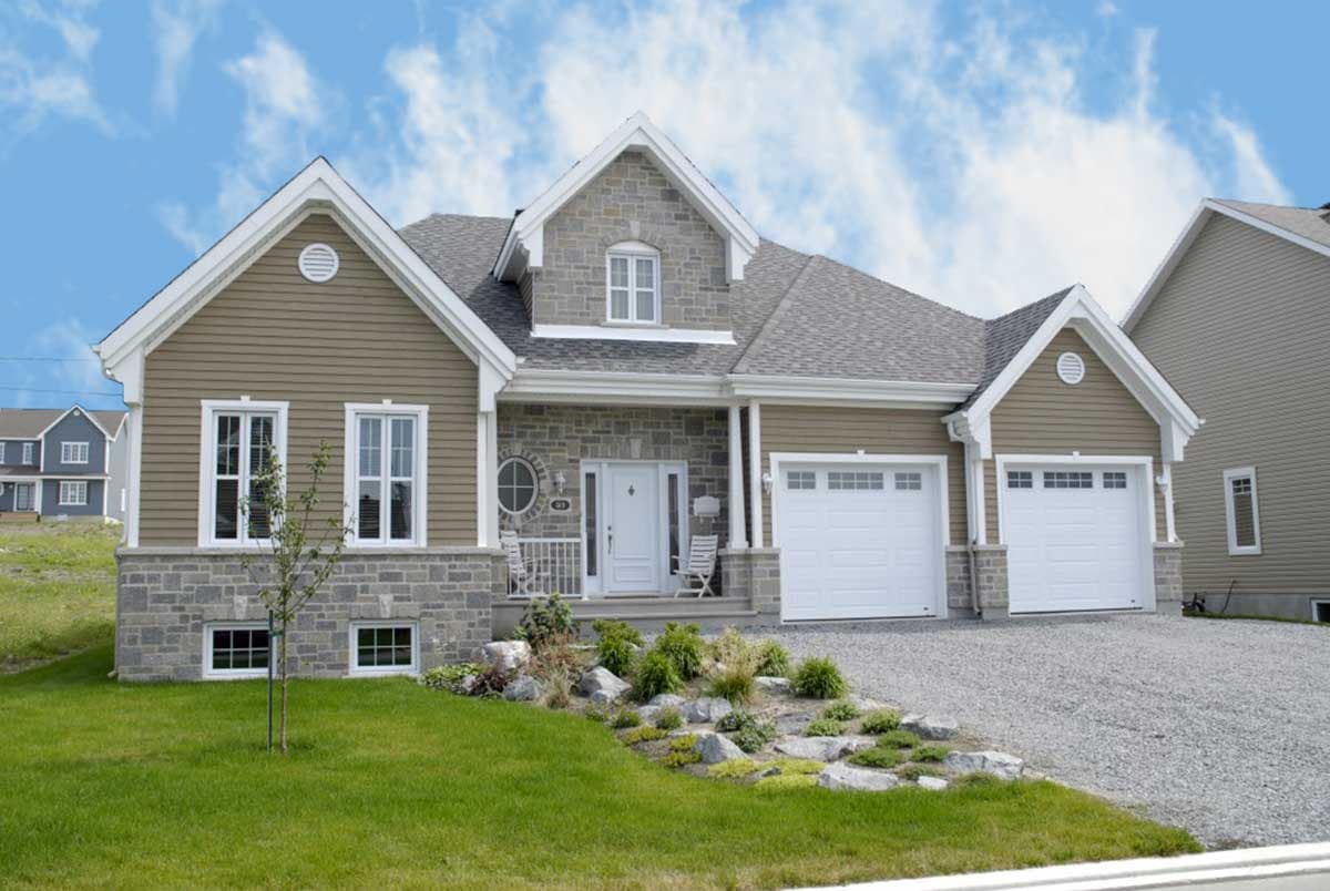 House plan exterior: Traditional style with stone and vinyl siding, gable rooflines, covered porch, and a three-car garage.