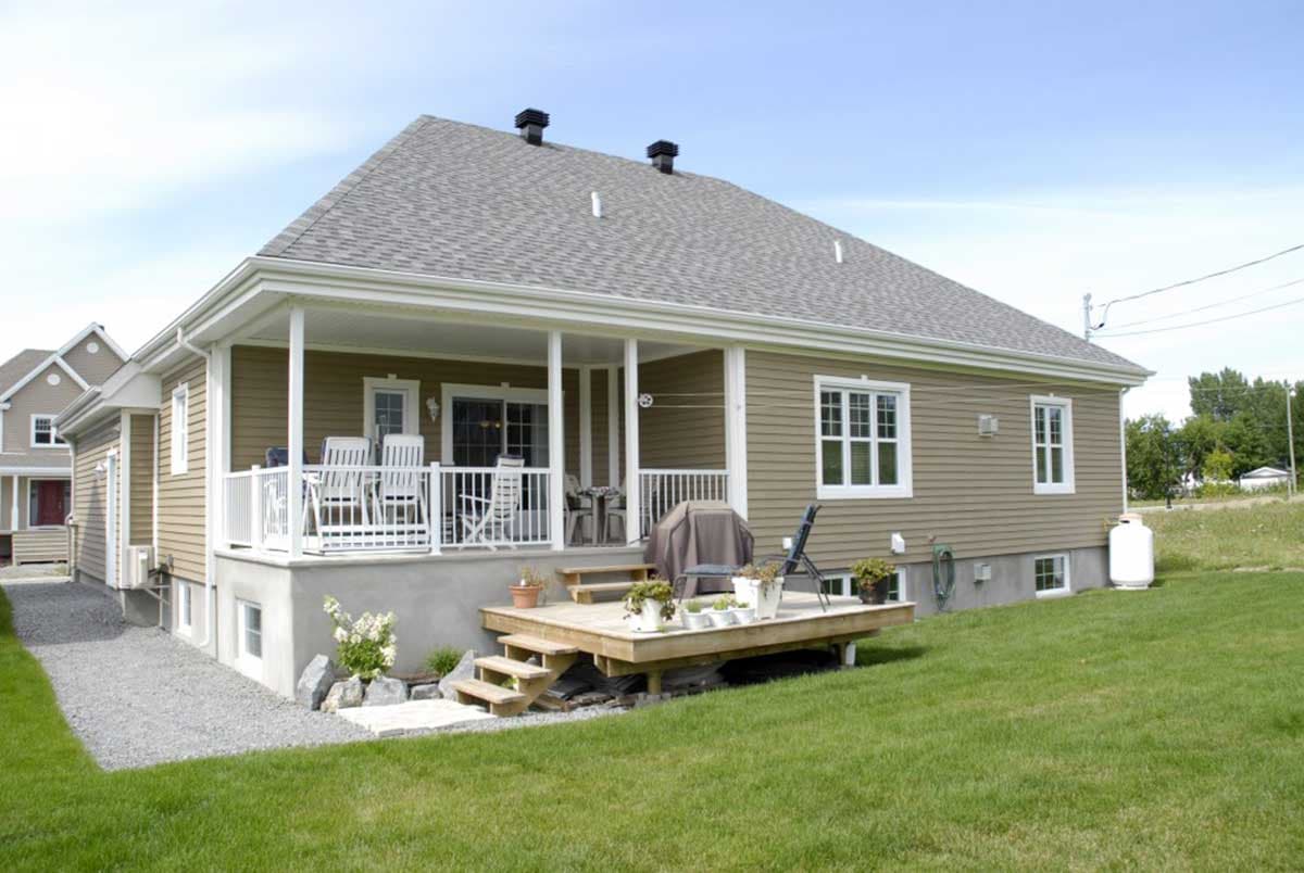 House plan exterior of a one-story home with a covered porch, wood deck, and gable rooflines.