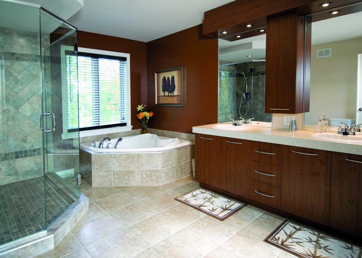 Bathroom with corner jacuzzi tub, glass-enclosed shower, double vanity with wood cabinetry, and beige tile flooring.