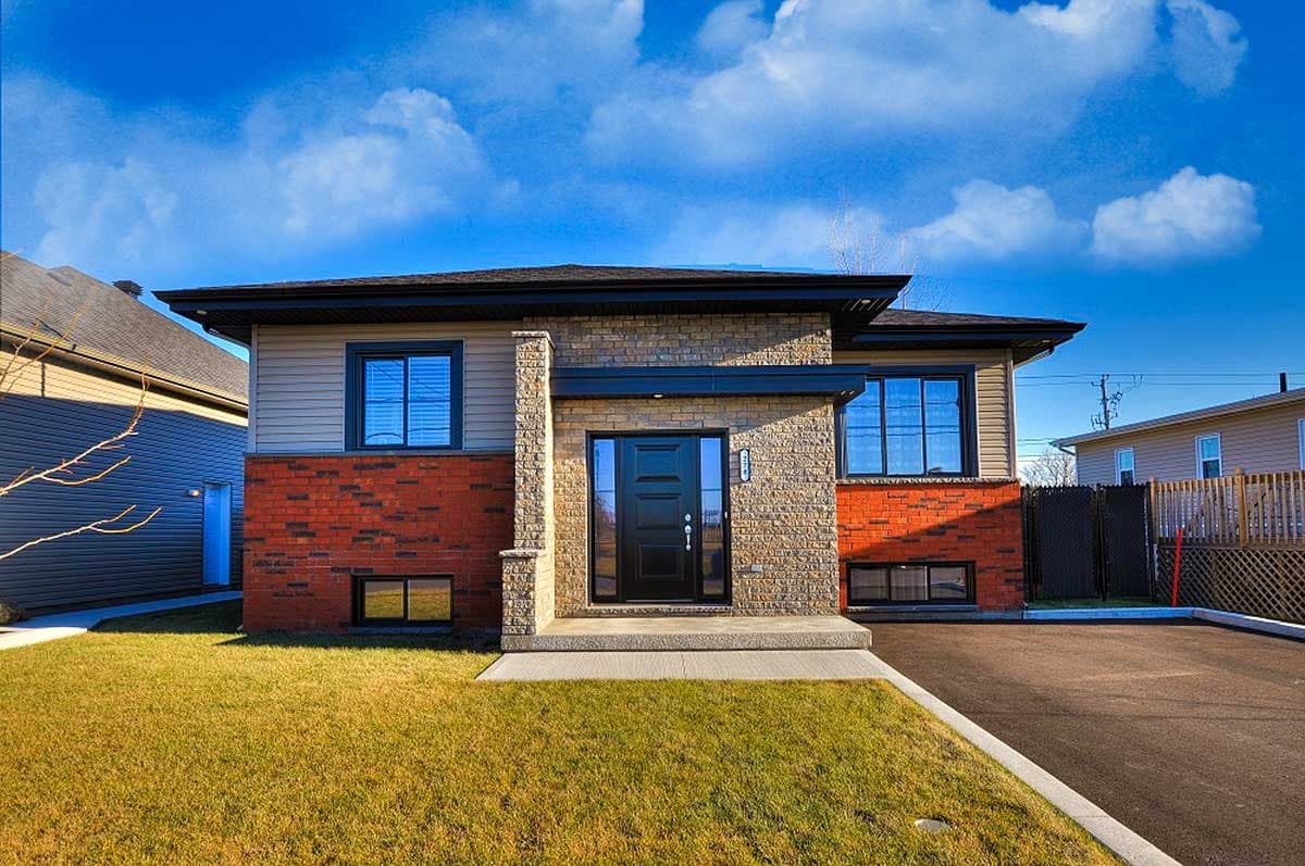 House plan exterior: Two-story home with brick and siding, prominent entryway, and dual rooflines.