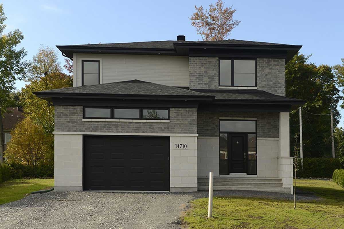 Modern two-story house plan exterior with stone and siding, large garage, and geometric rooflines.