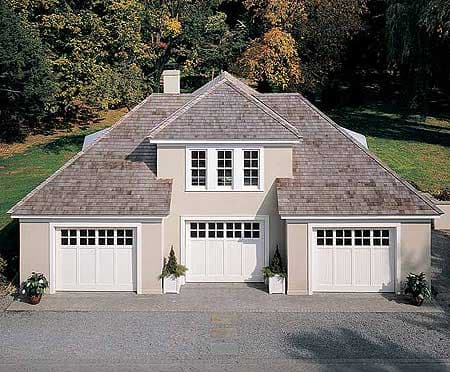 House plan exterior featuring a three-car garage, gambrel rooflines, and upper-level windows.