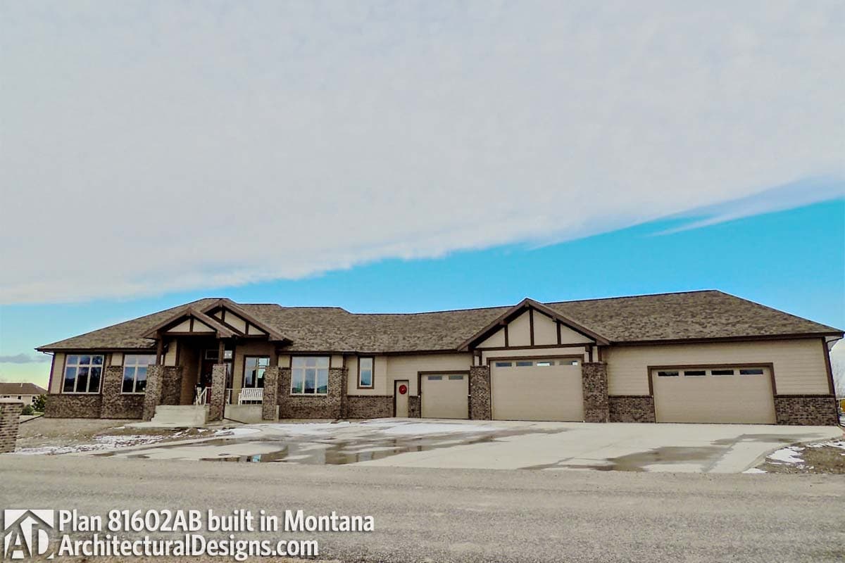 Ranch house plan exterior with gabled roof, stone accents, large windows, and three-car garage.