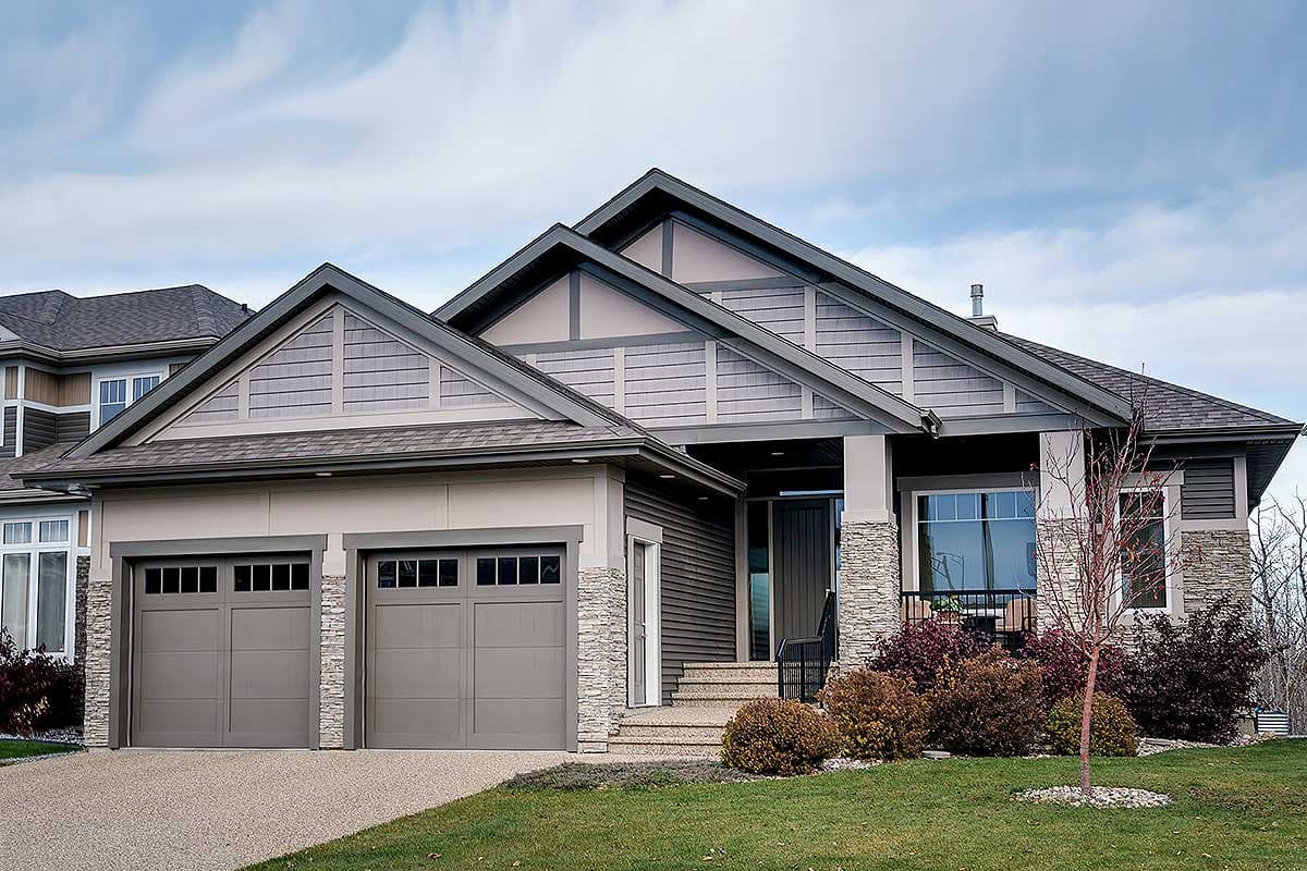 House plan exterior featuring a Craftsman style. Two-story home with multiple gables, stone accents, and a front-facing garage.