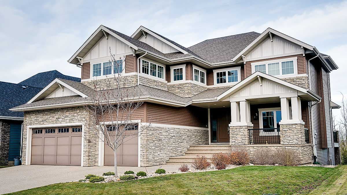 Exterior view of a two-story house plan with stone and wood siding, prominent gables, and a covered front entry with pillars.