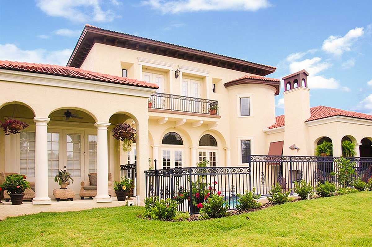 Mediterranean style house plan exterior with arched loggia, second-story balcony, and tile roof.