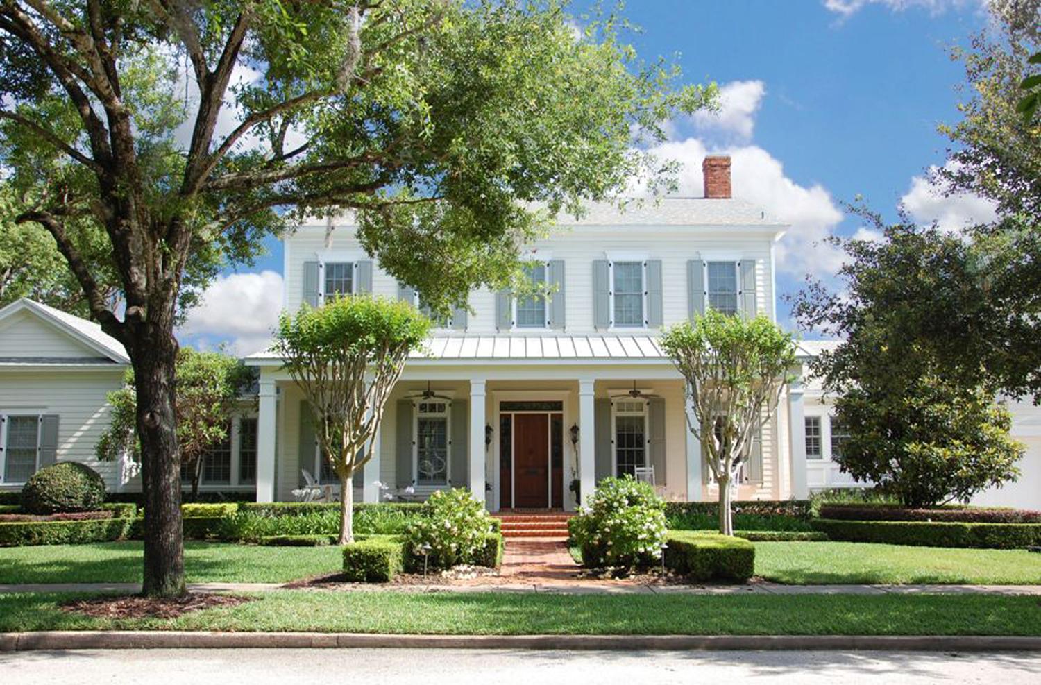 House plan exterior: Two-story home with a wraparound porch, gables, dormers, and dormer windows.