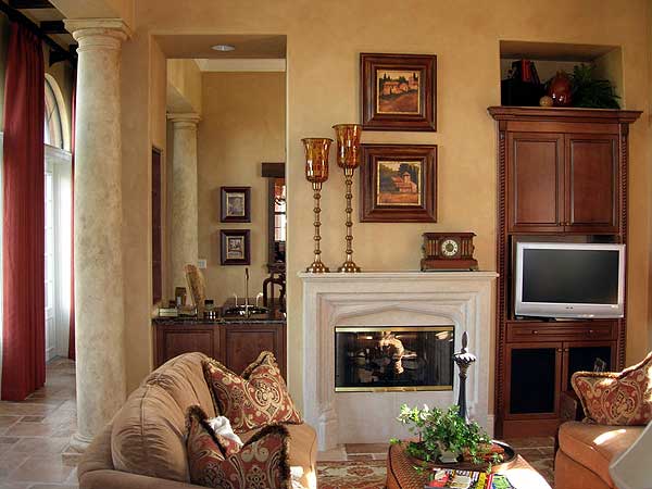 Interior living area with fireplace, built-in cabinetry, and decorative columns.