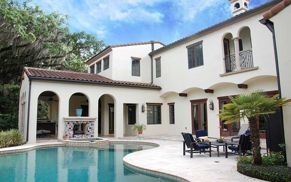 House plan exterior: Two-story Mediterranean style with arched loggia, fireplace, and pool.
