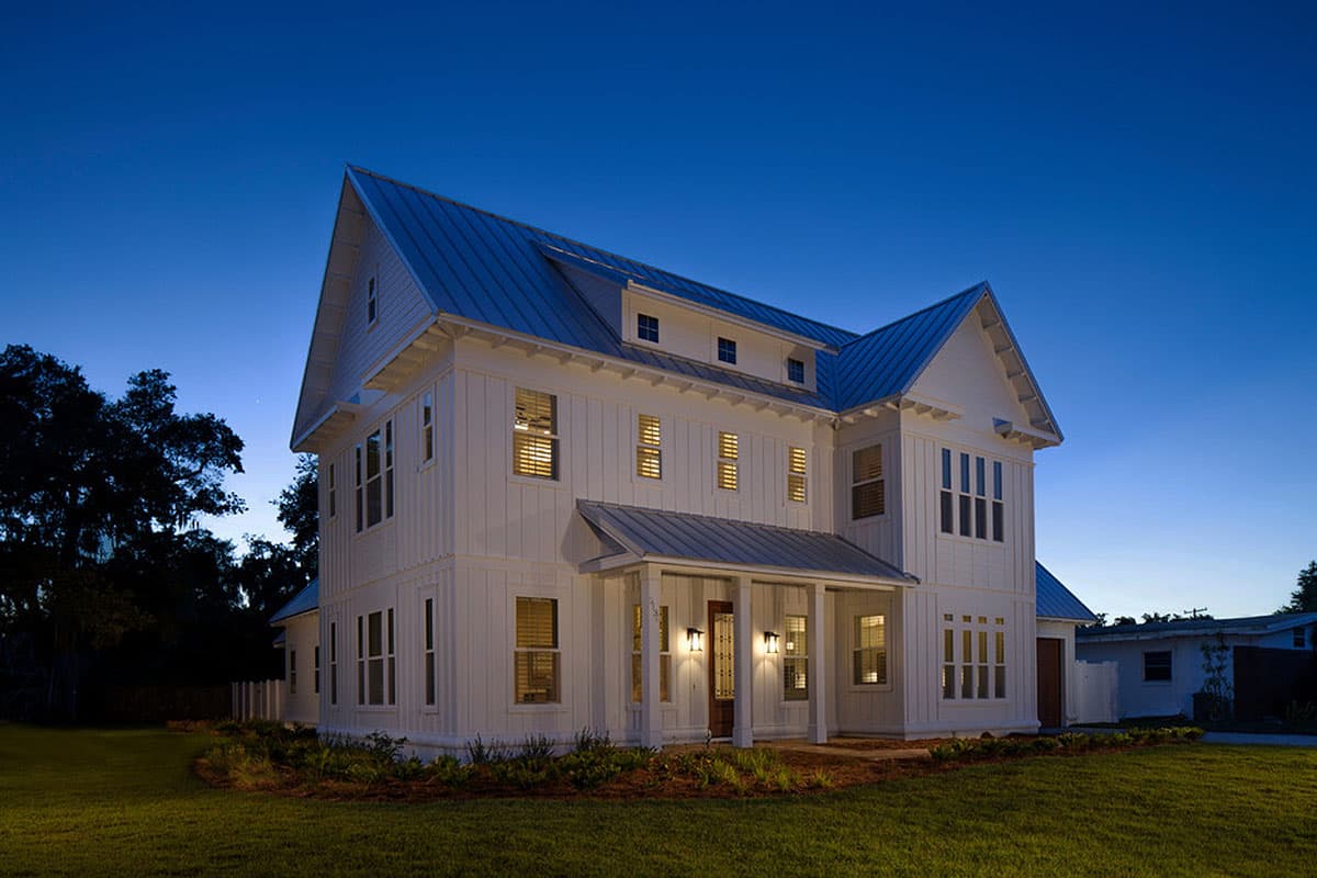 Modern farmhouse house plan exterior with metal roof, board and batten siding, multiple gables, dormers, and covered front porch.
