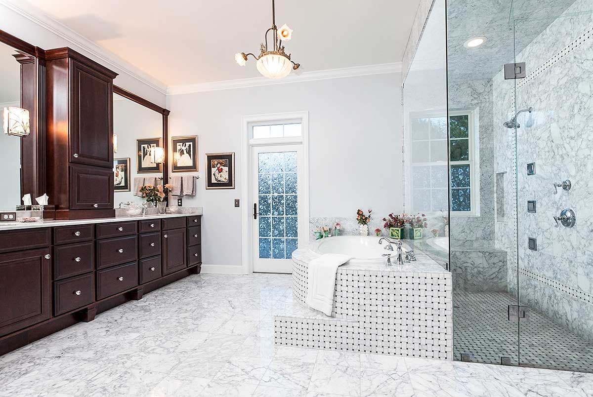 Bathroom with double vanity, soaking tub, and marble-tiled walk-in shower.