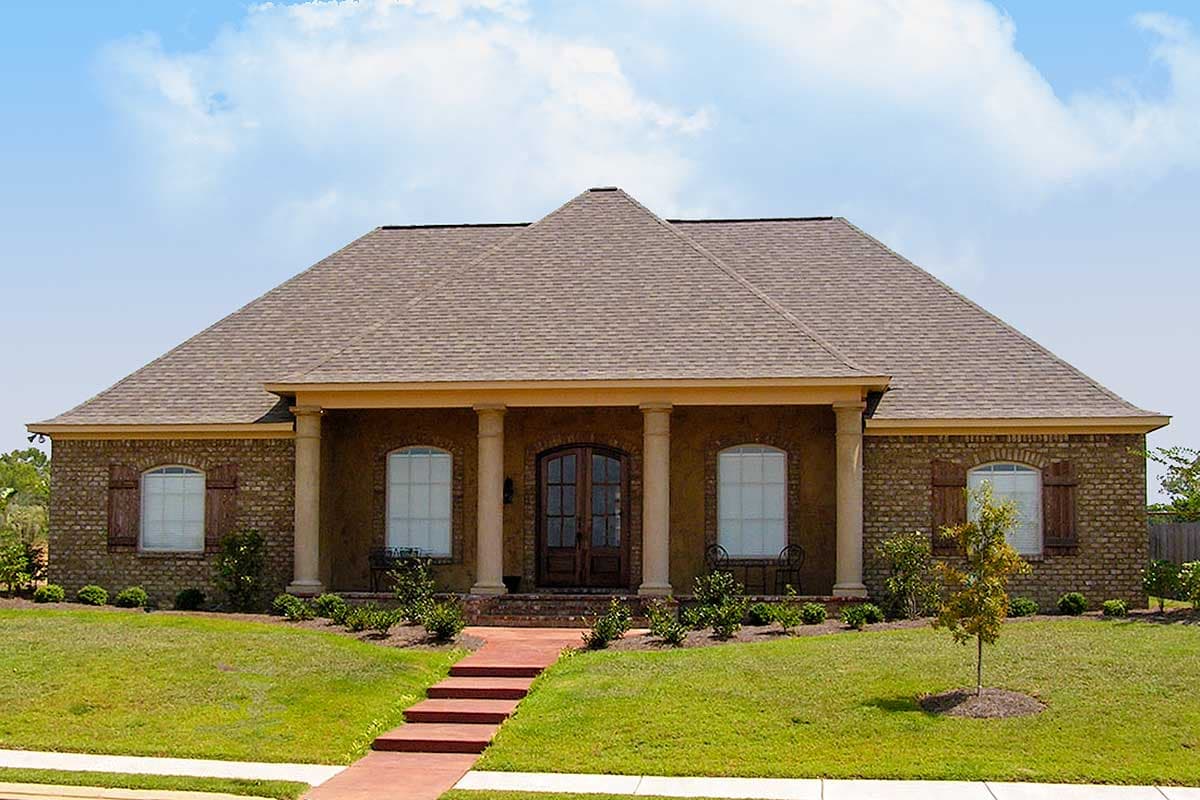 House plan exterior: One-story brick home with a covered front porch, double entry doors, arched windows with shutters, and a prominent hipped roof.
