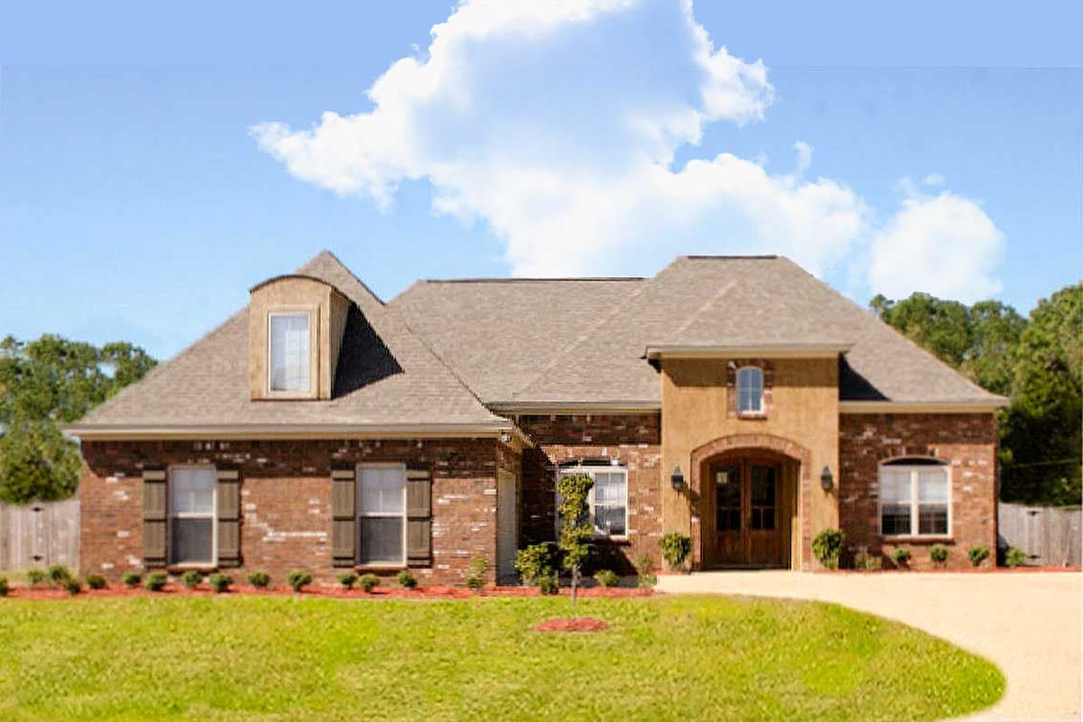 House plan exterior: two-story brick home with a mansard dormer, arched entryway, and asymmetrical rooflines.
