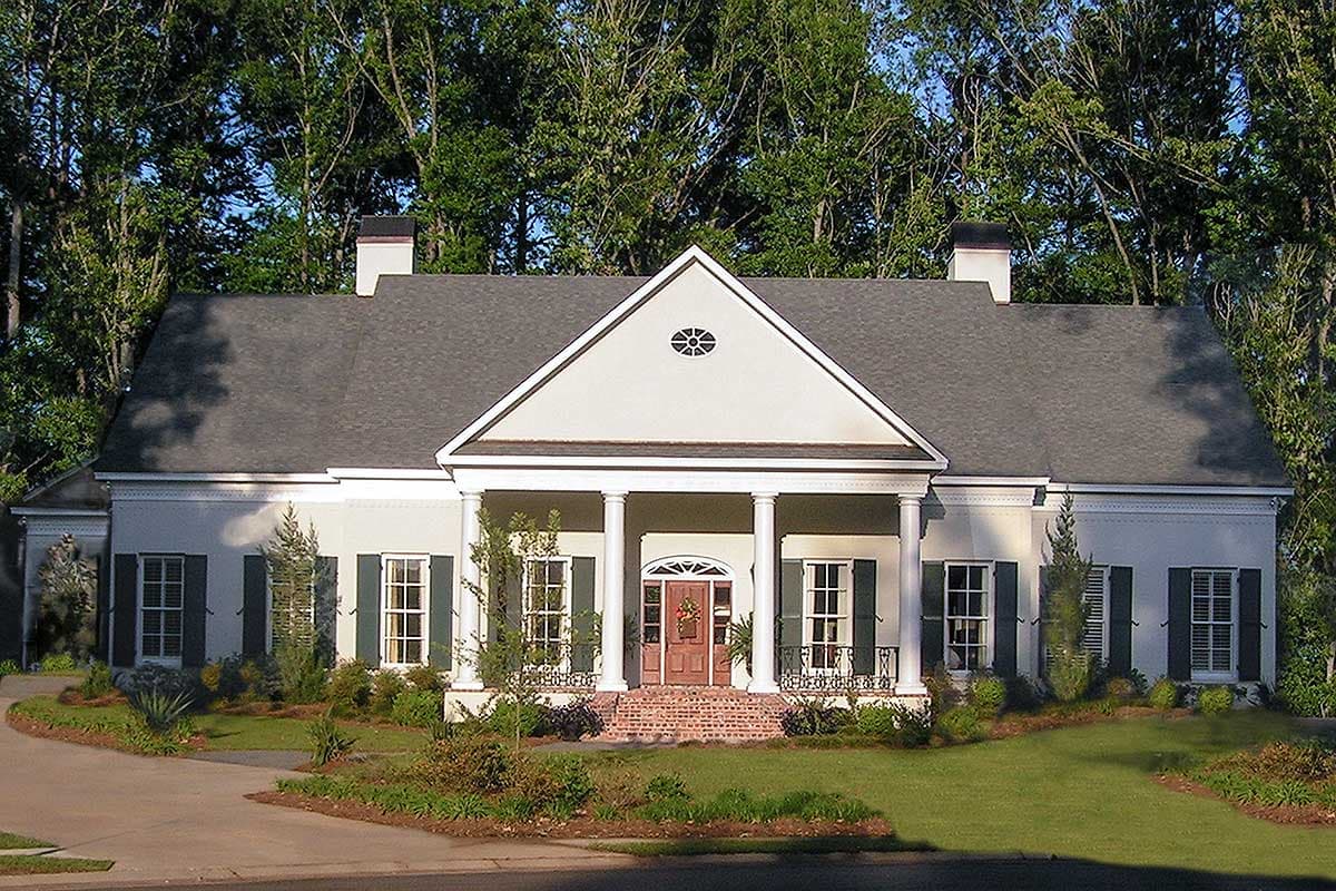 House plan exterior: Single-story house with a prominent portico supported by columns, central gable, and two chimneys.