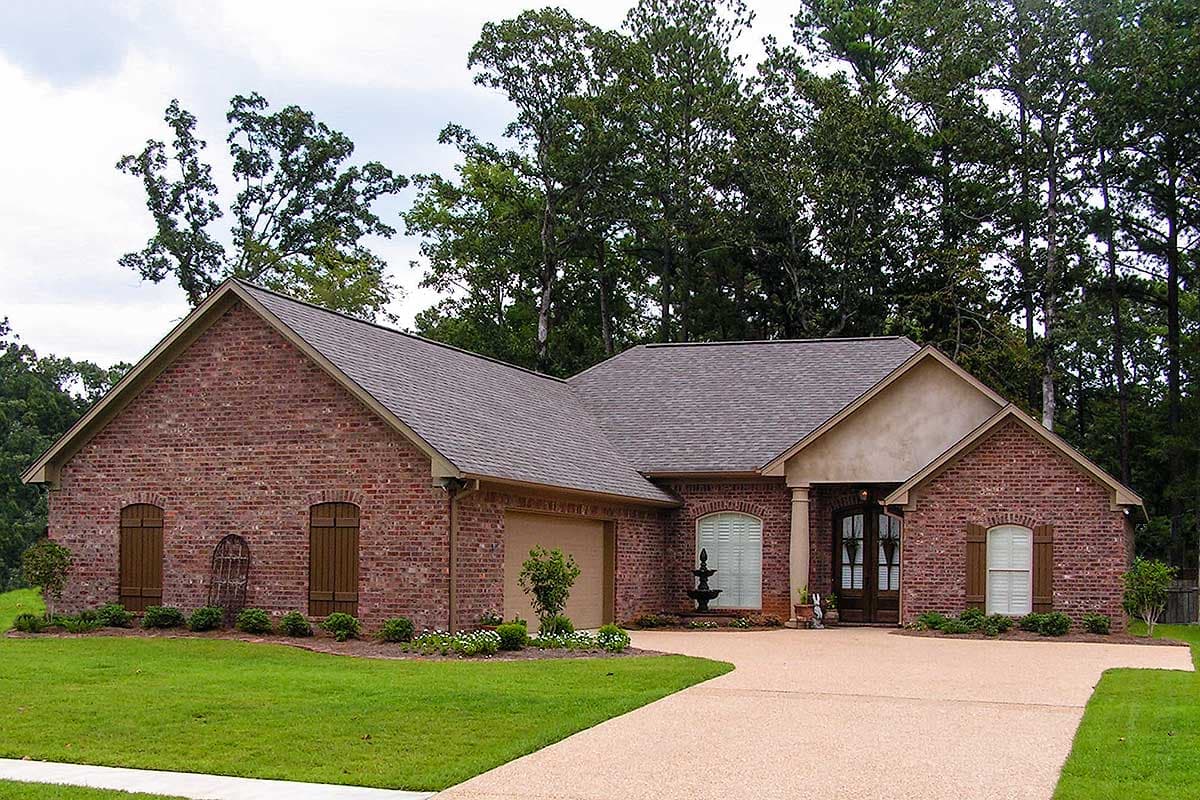 House plan exterior of a one-story brick home with a side-entry garage, arched windows, and a covered entry.