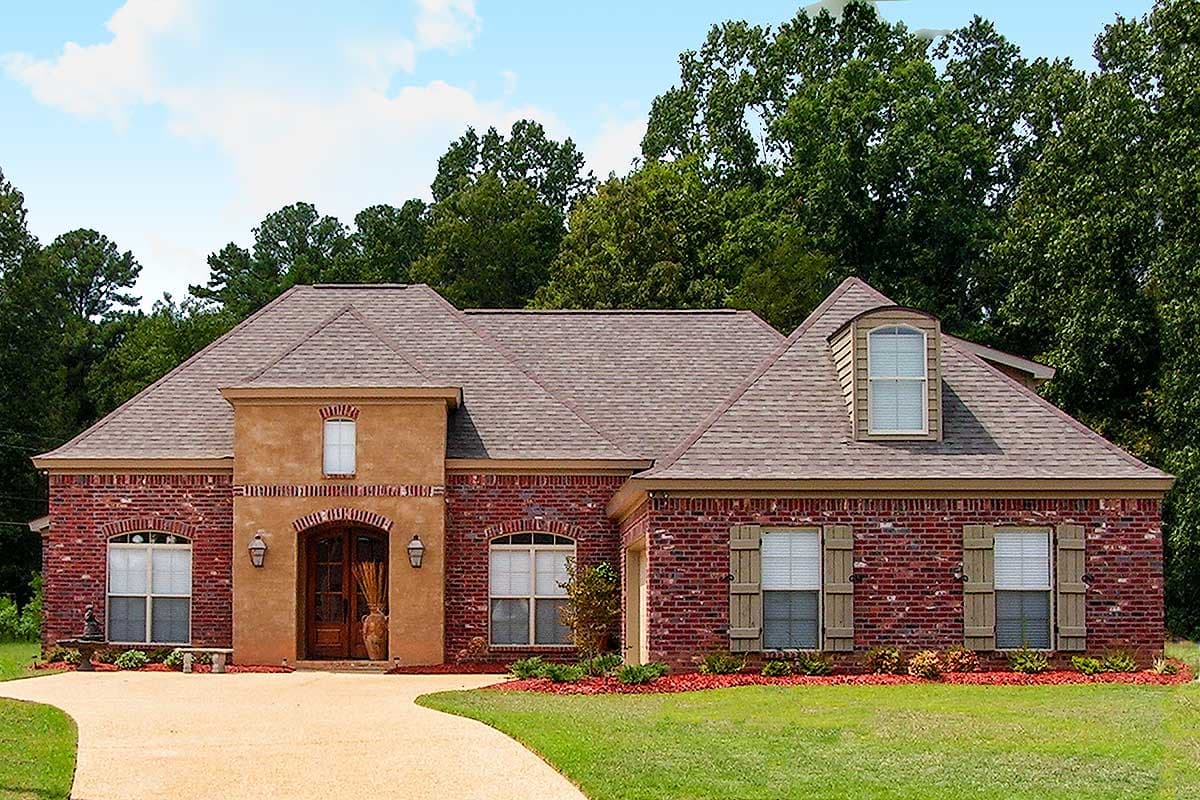 House plan exterior: Ranch style, brick facade, arched entry, dormer window, and gabled rooflines.