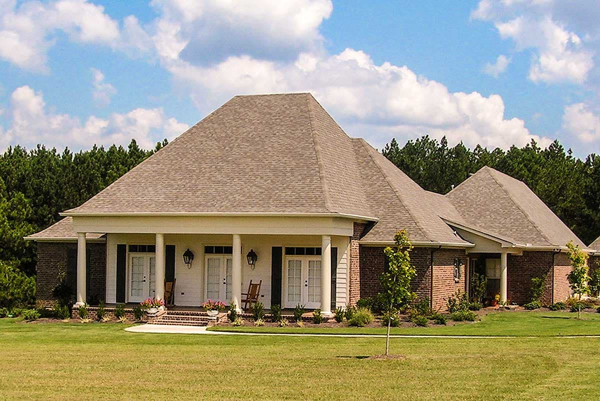 House plan exterior, one story, brick facade with covered porch, multiple gables, and a hip roof.