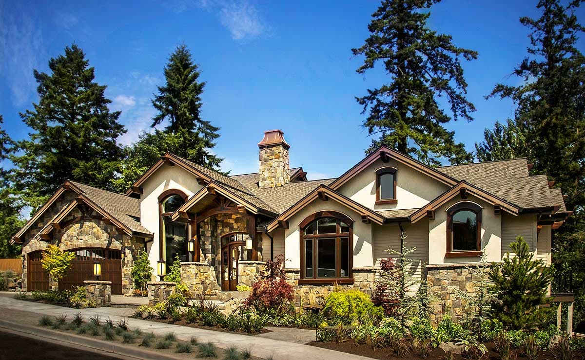 House plan exterior with stone accents, arched windows, dual garage doors, and a prominent stone chimney.