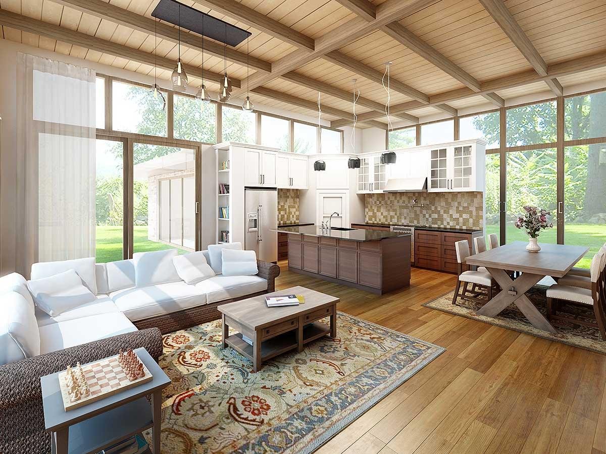 Open-concept living space with sectional sofa, kitchen island, dining area, and abundant natural light from floor-to-ceiling windows.