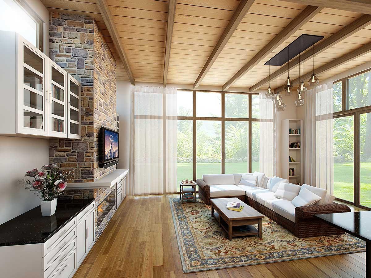 Living room with stone accent wall, vaulted wood-beamed ceiling, large windows, sectional sofa, coffee table, and media console.