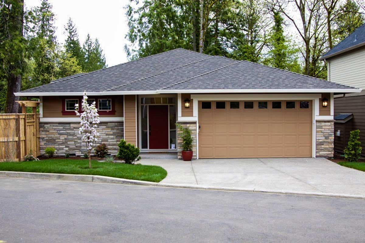 House plan exterior with stone veneer, single-story, and attached garage. Features a gabled roof and a red front door.