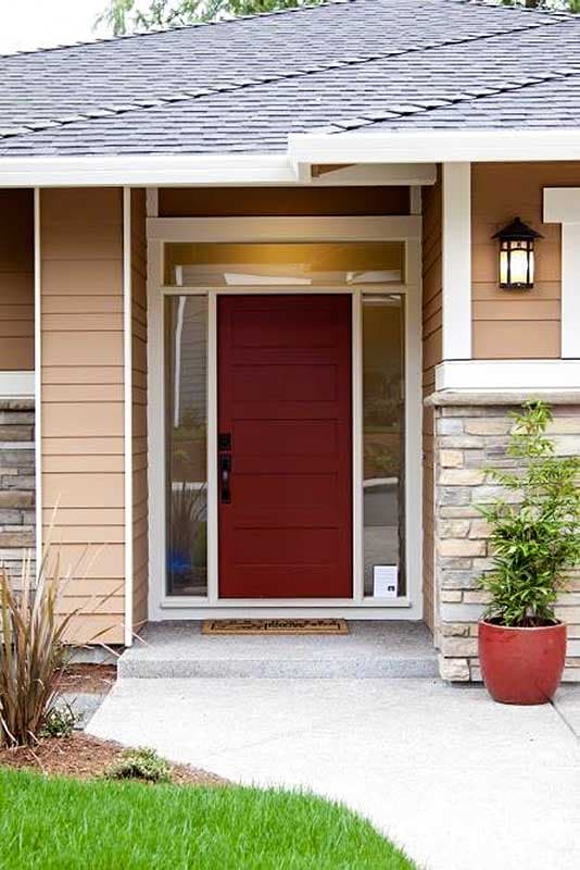 House plan exterior featuring a modern red door with glass sidelights, horizontal siding, and stone accents.