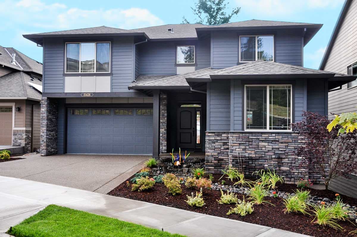 House plan exterior. Two-story, Modern style house with a stone veneer base, gabled roof, and attached garage. Includes a covered entry.