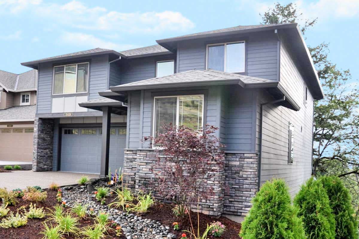 Two-story house plan exterior with stacked stone base, horizontal siding, dual garage doors, and layered rooflines.