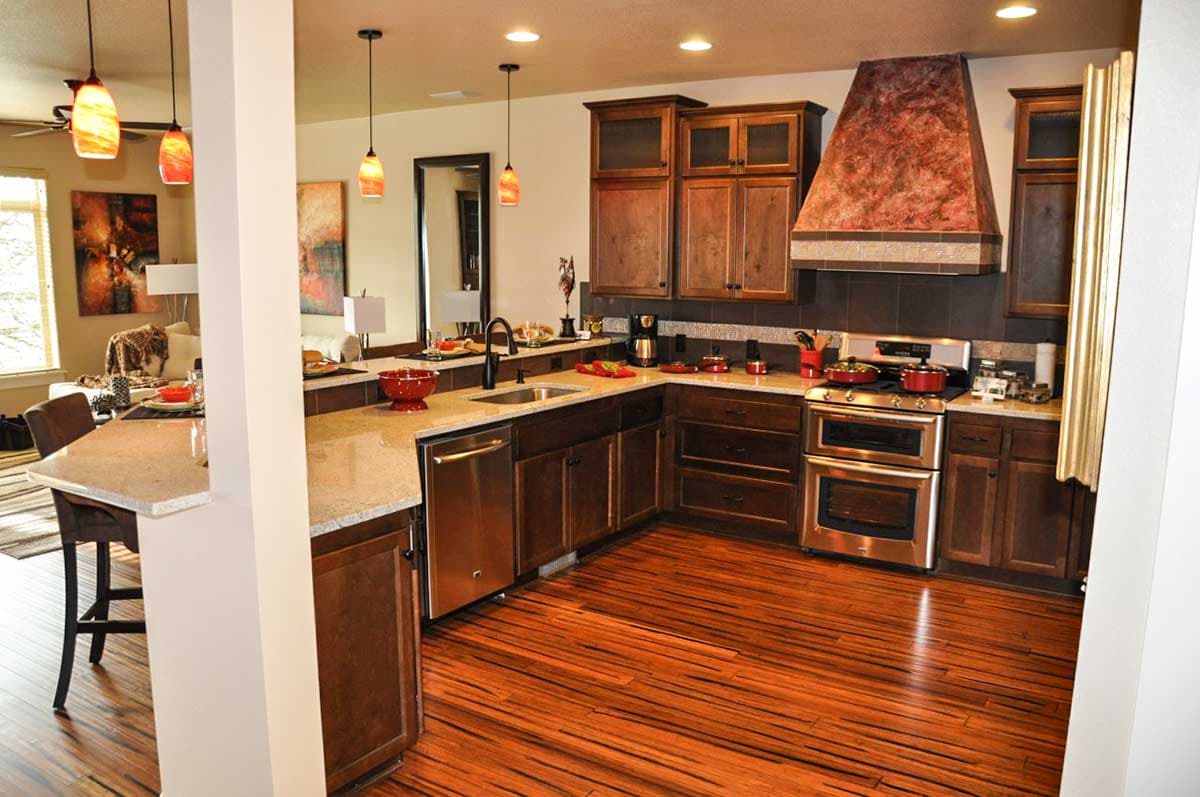 Kitchen with dark wood cabinets, granite countertops, stainless steel appliances, and a distinctive range hood.
