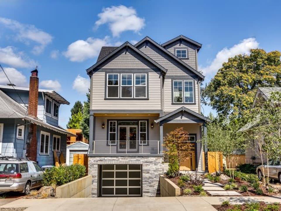 Modern Craftsman house plan exterior with three stories, prominent gables, covered porch, and lower-level garage.