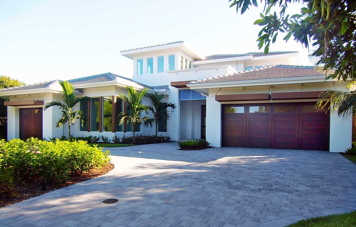 Modern house plan exterior with flat rooflines, large windows, a two-car garage, and a prominent entry.