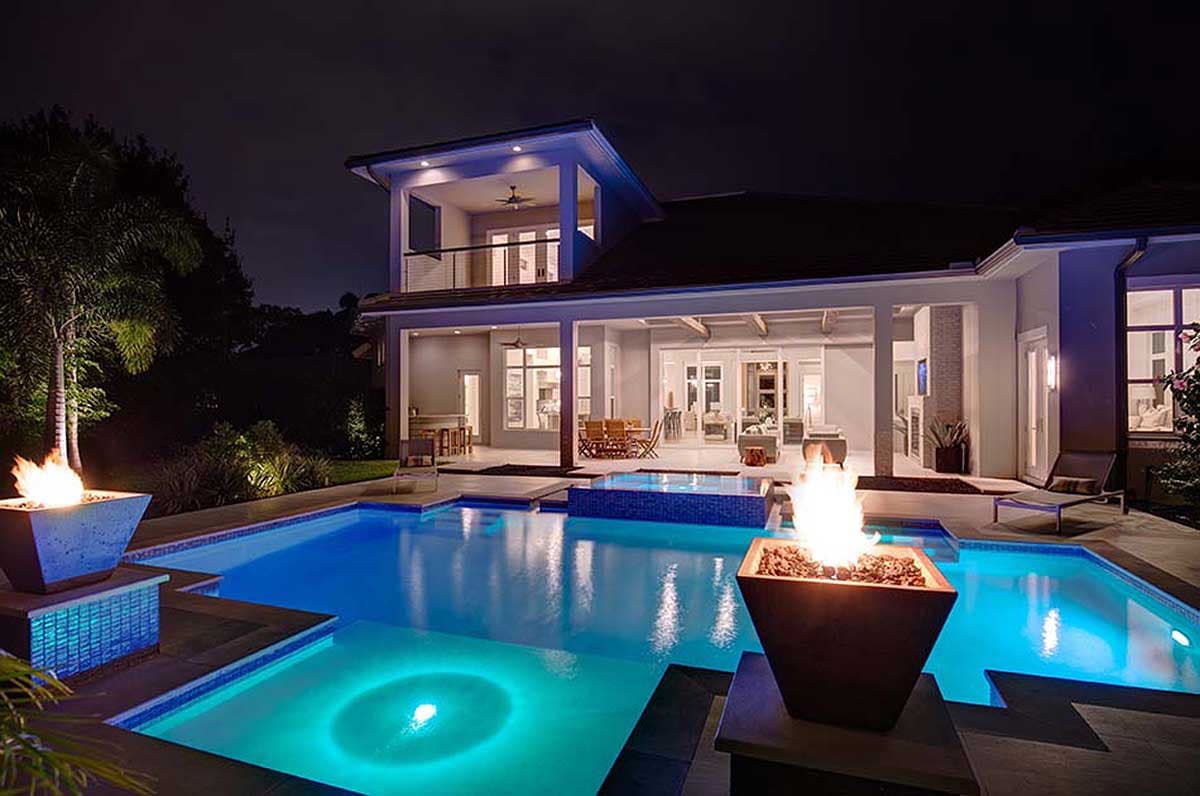 House plan exterior: Two-story modern home with a covered patio, balcony, and integrated pool with fire pits.