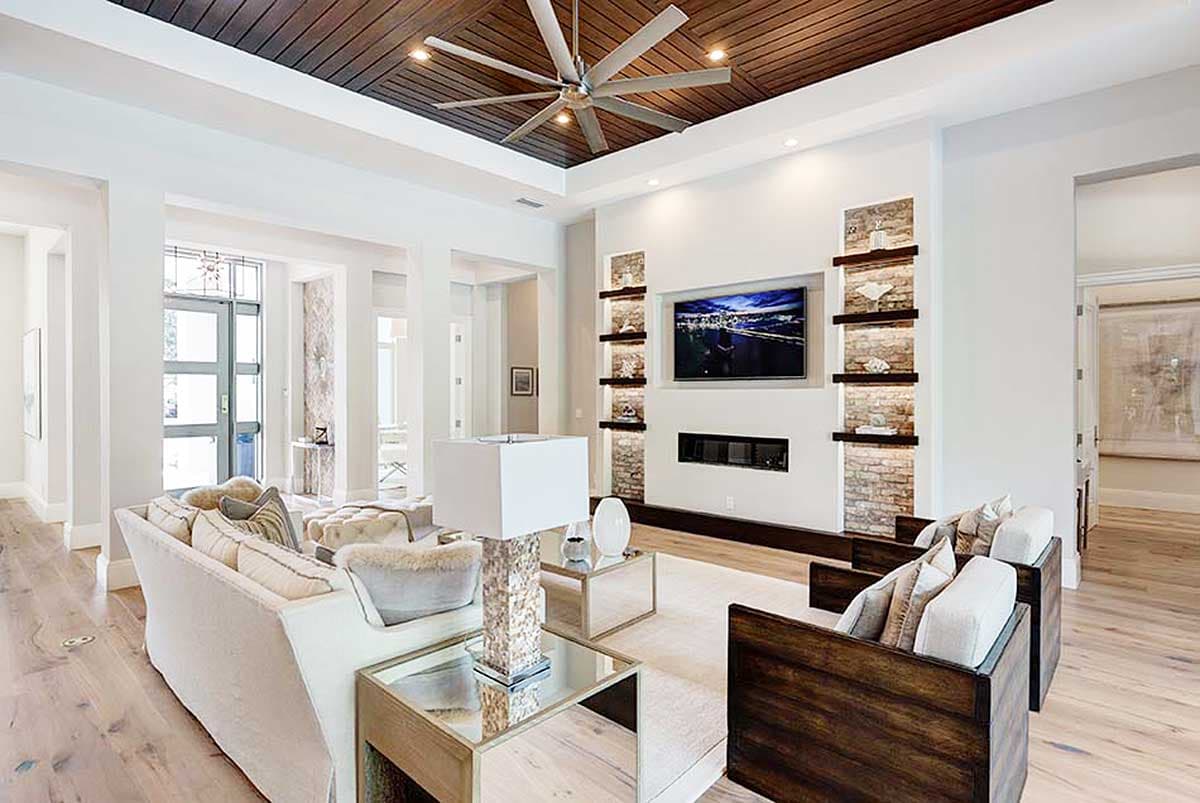 Great room with wood plank ceiling, recessed fireplace, media center, and open layout.
