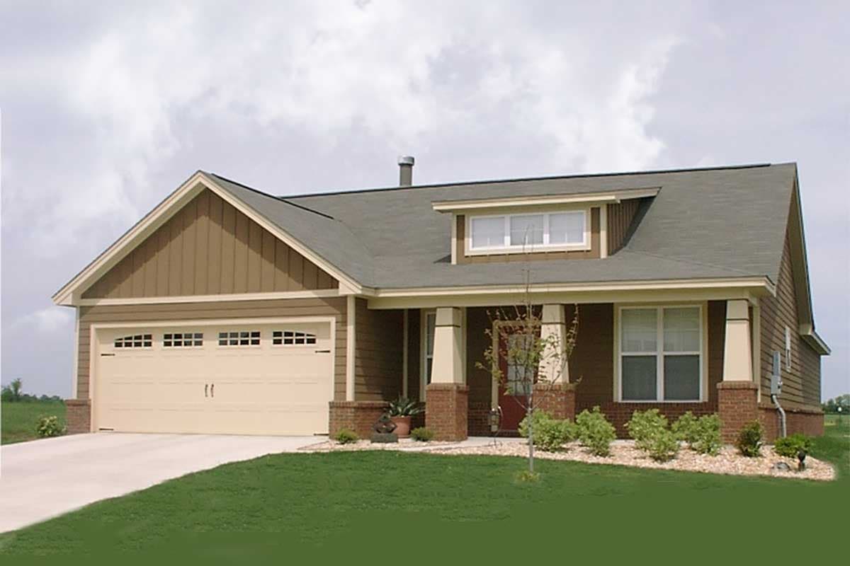 House plan exterior: Ranch style, one story, with attached garage, front porch with brick piers, and dormer.