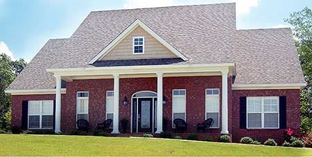 House plan exterior. Brick-clad two-story home with a wide front porch supported by columns, arched entry, and prominent gable.