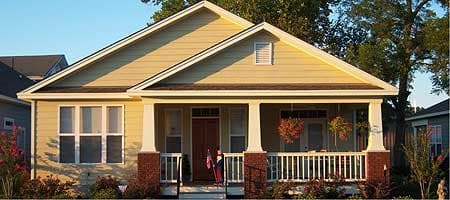 House plan exterior: One-story Craftsman home with a front porch supported by columns. Features include gabled roof and window dormer.