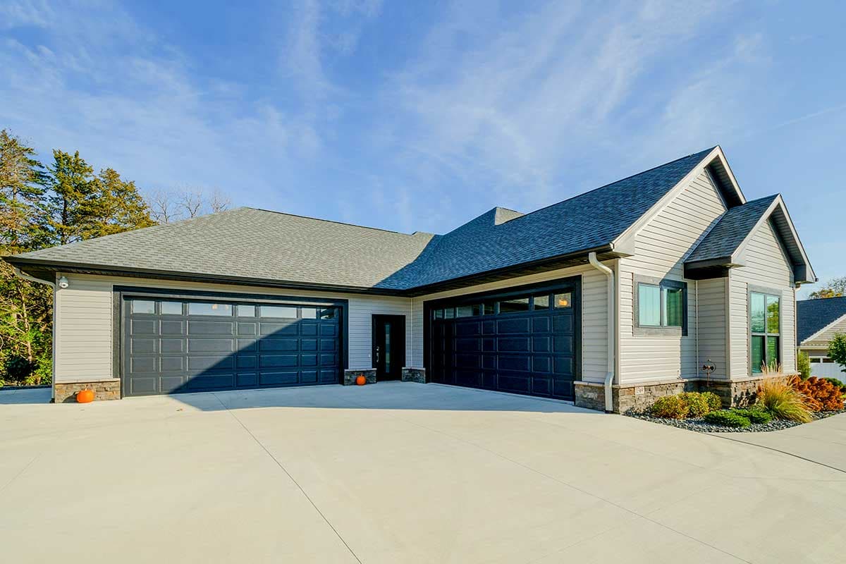Modern house plan exterior with a three-car garage, horizontal siding, and gabled rooflines.