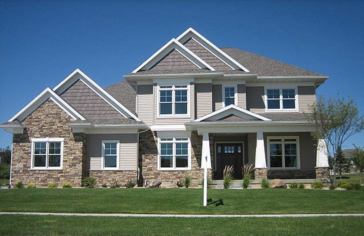 House plan exterior. Two-story house with stone and siding facade, gabled rooflines, and a covered front porch supported by columns.