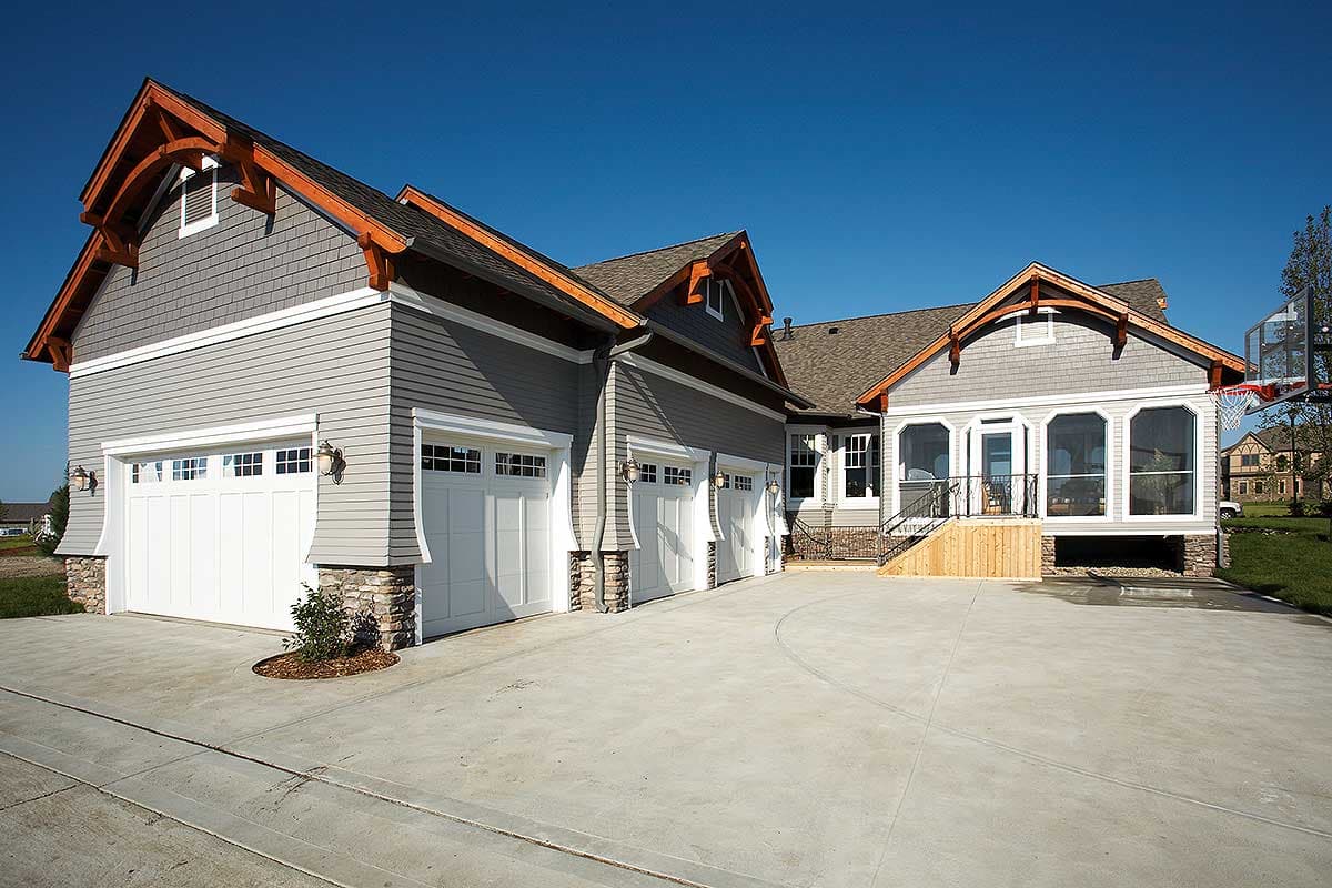 House plan exterior with three-car garage, gabled rooflines, cedar shake siding, and screened porch.