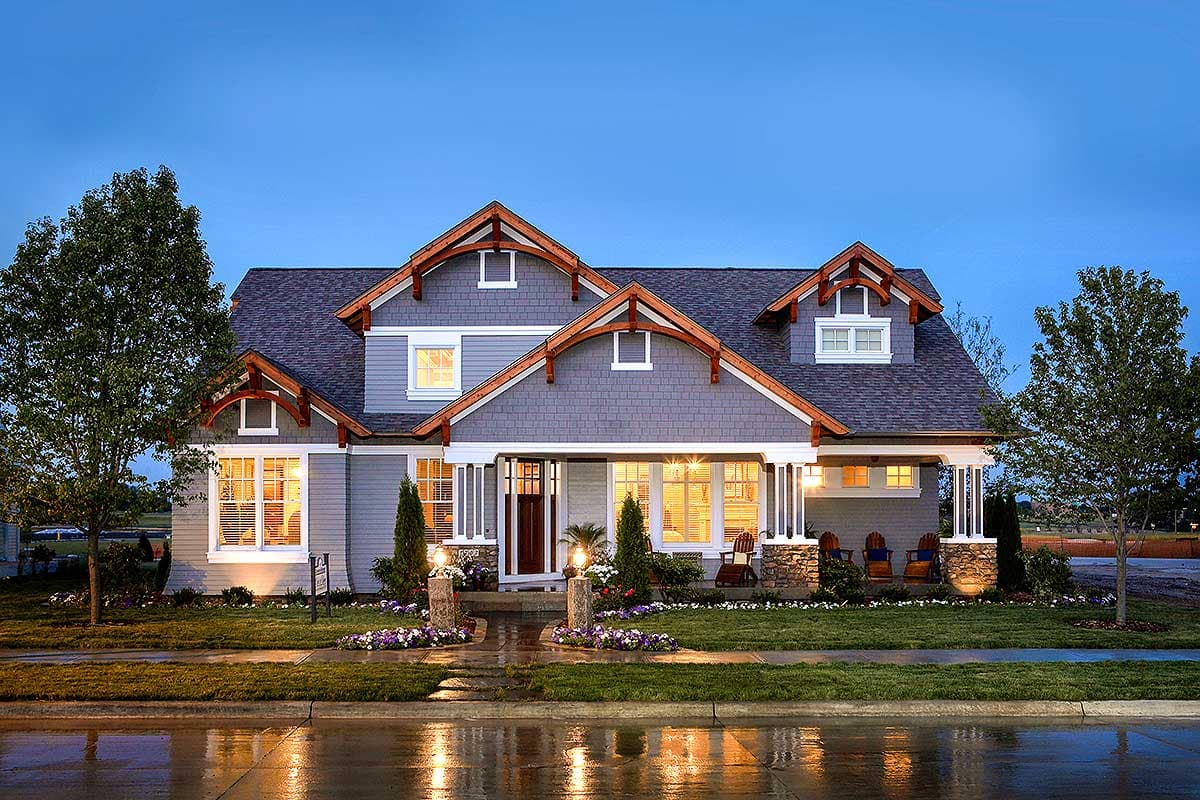 House plan exterior in Craftsman style. Features include gables, dormers, and a covered porch with stone columns. Two-story house.