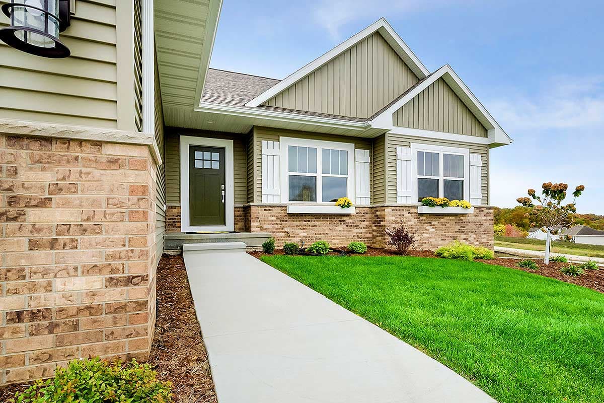 House plan exterior showing a one-story Modern Farmhouse with a gabled roof, prominent front door, and two bay windows with shutters.