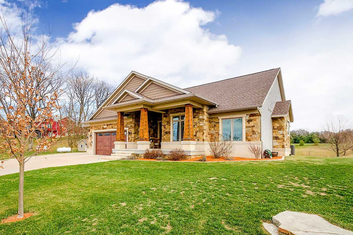 House plan exterior: Ranch style with stone and siding, covered entry with wood columns, and attached garage.
