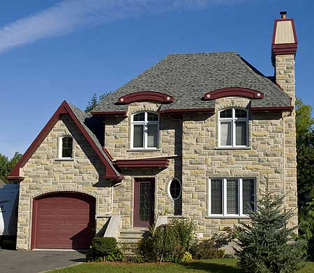 Two-story house plan exterior with stone facade, prominent gabled dormers, arched windows, and side-entry garage.