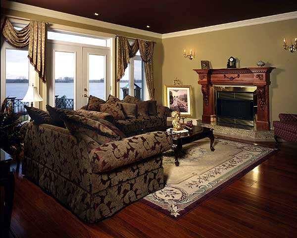 Living room with fireplace, sectional sofa, coffee table, and French doors opening to a water view.
