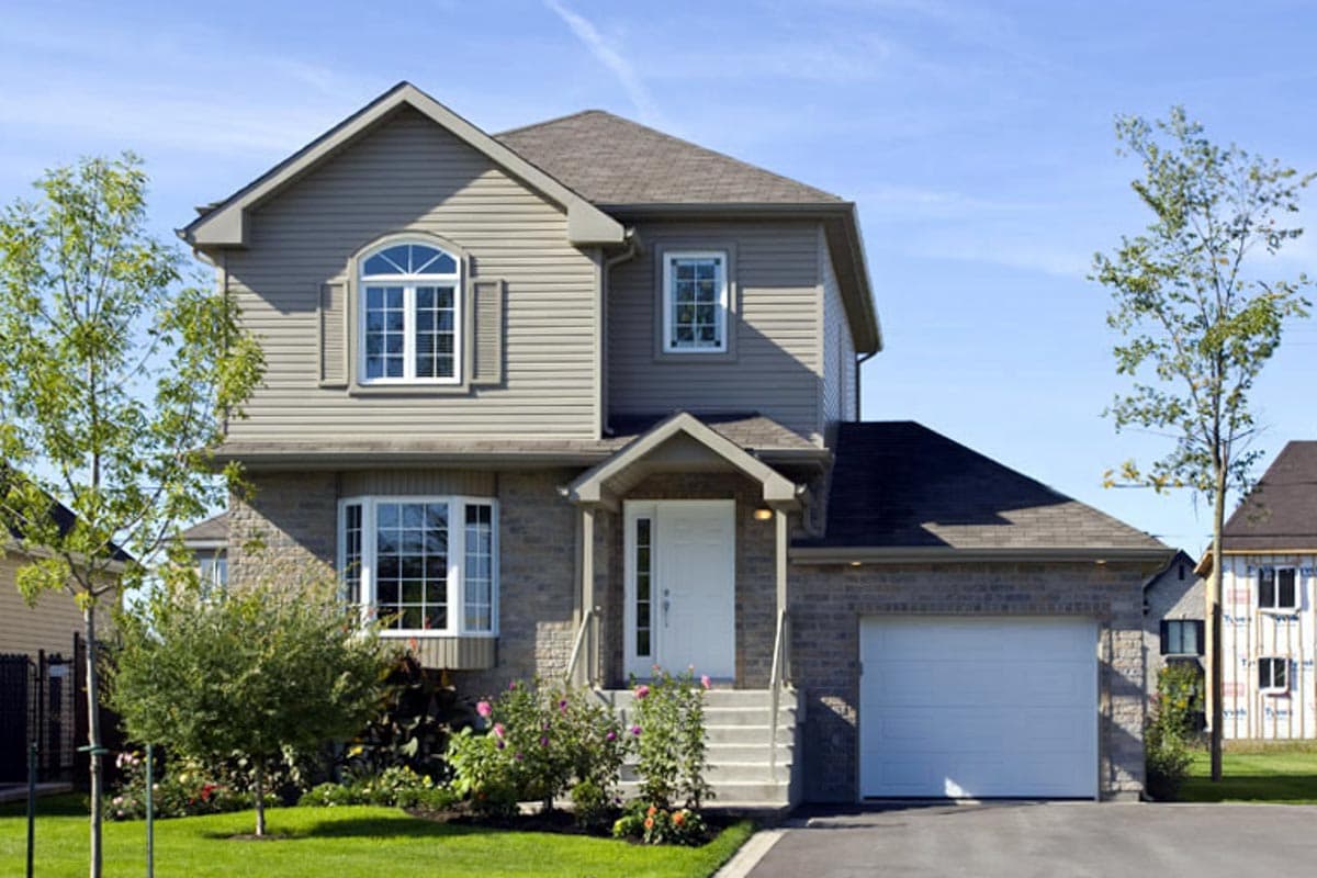 Two-story house plan exterior with stone facade, arched window, bay window, gable roof, and attached garage.