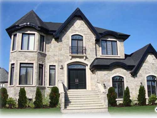 House plan exterior: Two-story stone residence with a turret, prominent gables, arched windows, and a wide front entrance.