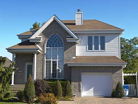 Two-story house plan exterior with stone facade, arched window, gabled rooflines, and attached garage.